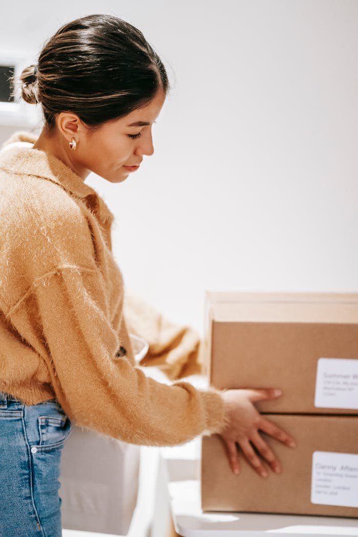 A young woman arranges delivery boxes at home, symbolizing online shopping and logistics.